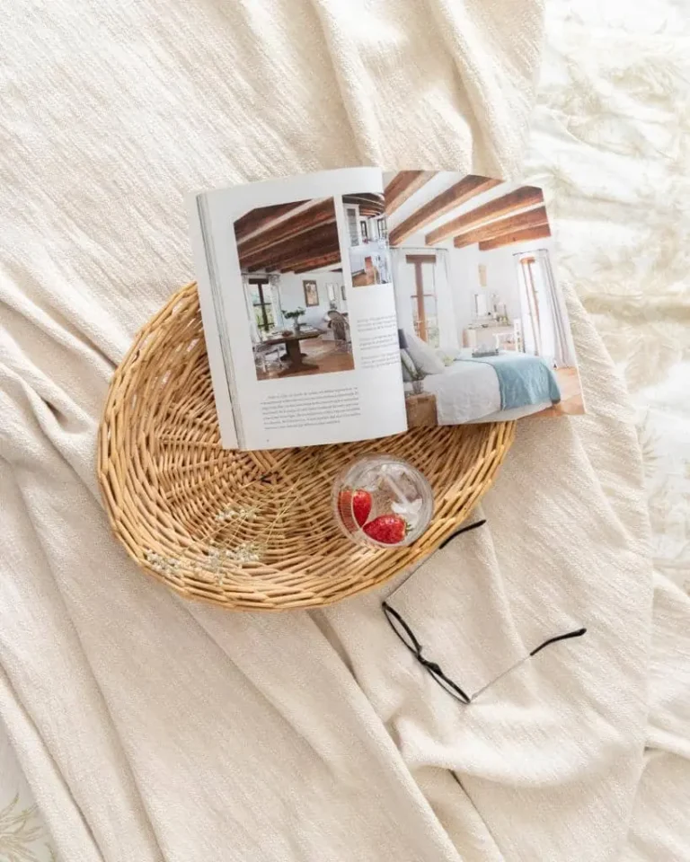 Revista de diseño de interiores sobre una bandeja de mimbre en el dormitorio del acogedor Barrio de Salamanca, Madrid