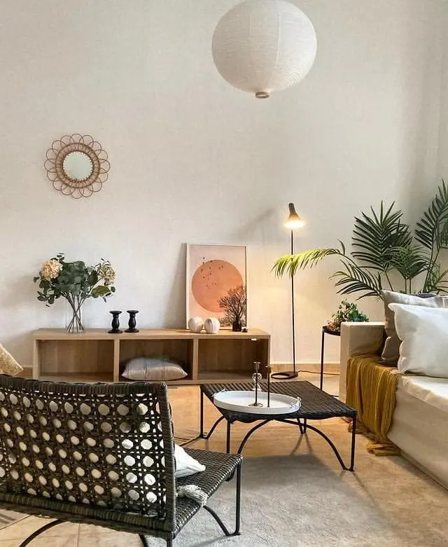 Moderno salón decorado con muebles de mimbre y elementos naturales en un proyecto de Home Staging en Puig Santa María, Valencia